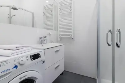 a white bathroom with a washing machine and a shower at NEW APARTMENT! Jewish quarter! in Kraków