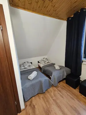 two twin beds in a room with a window at Zawoja Nad Koroną z jacuzzi in Zawoja