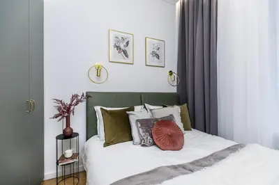 a bedroom with a bed with white sheets and pillows at Wielopole 7 Apartment 2 rooms in Kraków