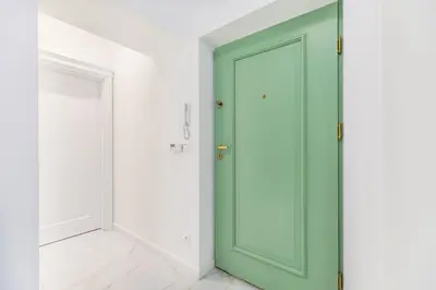 a green door in a room with white walls at Wielopole 7 Apartment 2 rooms in Kraków