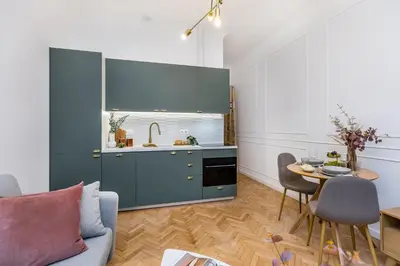 a kitchen with a blue cabinet and a table at Wielopole 7 Apartment 2 rooms in Kraków