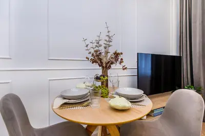 a dining room table with a tv and a wooden table at Wielopole 7 Apartment 2 rooms in Kraków