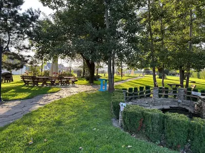 a park with benches and tables in the grass at Restauracja i Hotel Oberża Wilczy Głód in Krzyszkowice