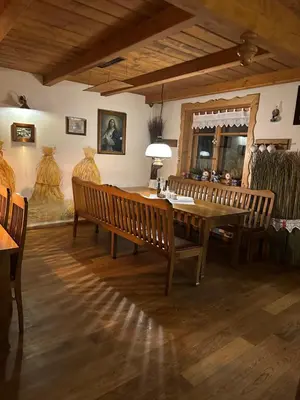 a dining room with a wooden table and benches at Restauracja i Hotel Oberża Wilczy Głód in Krzyszkowice