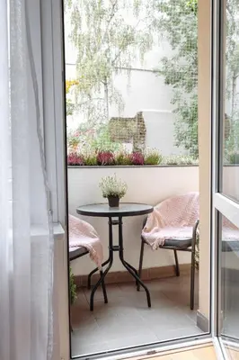 a balcony with a table and chairs and a window at Tomasza 25 Apartament 3 in Kraków