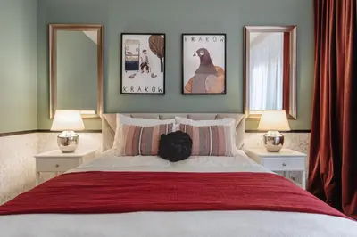 a bedroom with a large bed with three pictures on the wall at Tomasza 25 Apartament 3 in Kraków
