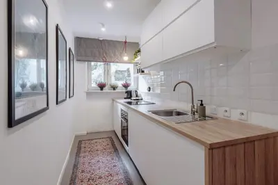 a white kitchen with a sink and a counter at Tomasza 25 Apartament 3 in Kraków