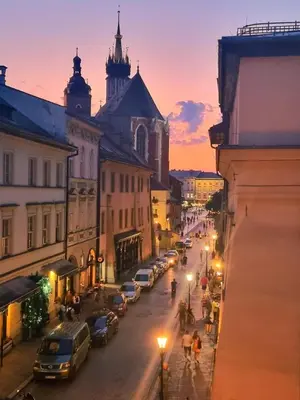 a city street at night with cars parked on the street at Studio Flat With a View in Kraków