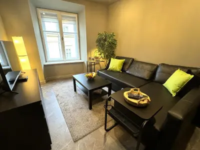 a living room with a couch and a table at Studio Flat With a View in Kraków