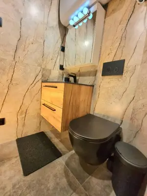 a bathroom with a black toilet and a mirror at Studio Flat With a View in Kraków