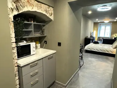 a kitchen with a microwave and a bed in a room at Studio Flat With a View in Kraków