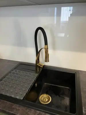 a black sink with a gold faucet at Mieszkaj U Marty w GRÓDKU in Jaworzno