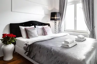 a bedroom with a bed with towels and a vase of flowers at Househost Apartment:Łobzowska 22 in Kraków