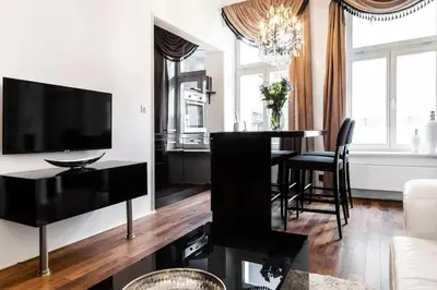 a living room with a black table and a television at Househost Apartment:Łobzowska 22 in Kraków