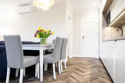 a dining room with a white table and chairs at HOUSEHOST Apartment : Sarego Street in Kraków