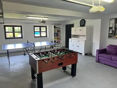 a living room with a foosball table and a purple couch at Stodoła Chillout Apartments in Marszowice