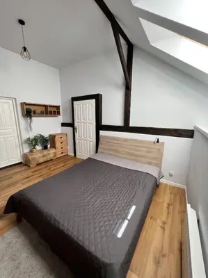 a bedroom with a large bed in a attic at Stodoła Chillout Apartments in Marszowice