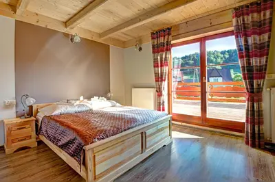 a bedroom with a bed and a large window at Noclegi Styrnol & SPA in Zawoja