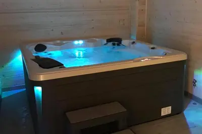 a bath tub with blue lights in a room at Noclegi Styrnol & SPA in Zawoja