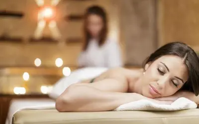 a woman laying on a towel in a bath tub at Noclegi Styrnol & SPA in Zawoja