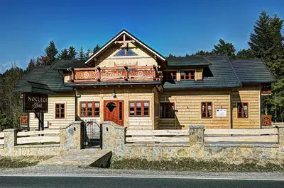 a large wooden house with a black roof at Noclegi Styrnol & SPA in Zawoja