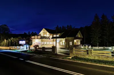 a house is lit up at night next to a road at Noclegi Styrnol & SPA in Zawoja