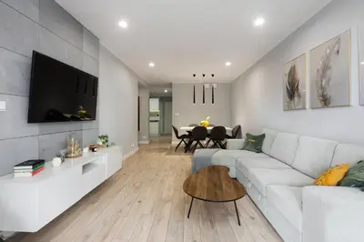 a living room with a white couch and a table at Zlota Jesien apartment by NEARTO PL in Kraków