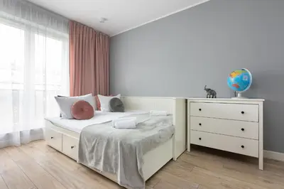 a bedroom with a bed with a dresser and a window at Zlota Jesien apartment by NEARTO PL in Kraków