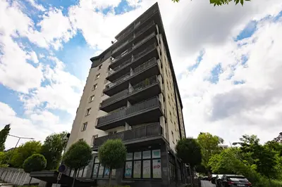 a tall building on a street with a cloudy sky at Zlota Jesien apartment by NEARTO PL in Kraków