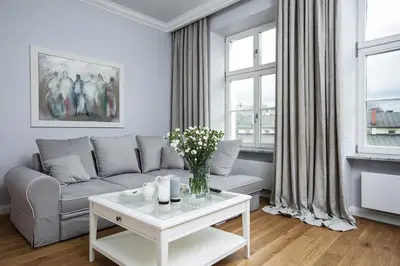 a bedroom with a bed and a chair at MINT Luxury Apartments at the Main Square in Kraków