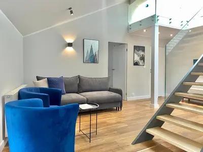 a hallway with windows and a staircase with a couch at MINT Luxury Apartments at the Main Square in Kraków