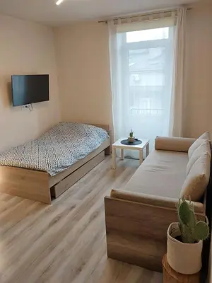 a bedroom with two beds and a tv on the wall at Studio near Old Town in Kraków