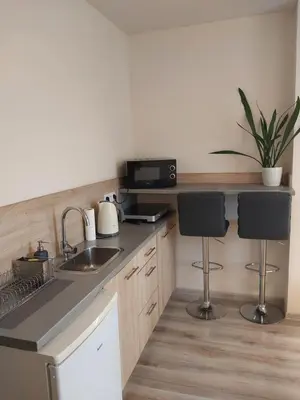 a kitchen with a sink and two bar stools at Studio near Old Town in Kraków