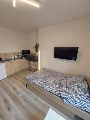a room with a bed and a flat screen tv at Studio near Old Town in Kraków