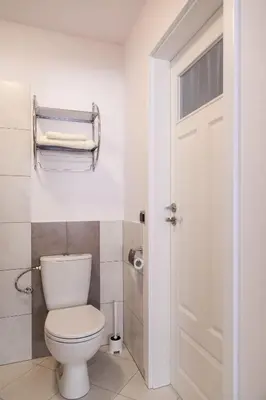 a bathroom with a white toilet and a door at Kraków Cosy 3 room 2 bathroom Old Town in Kraków