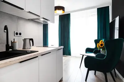 a kitchen with white cabinets and a table and chairs at HOUSEHOST Apartments: Miodowa 42/12b Street in Kraków