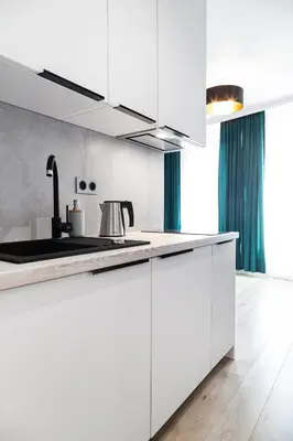 a kitchen with white cabinets and a sink at HOUSEHOST Apartments: Miodowa 42/12b Street in Kraków