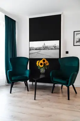two green chairs and a table with a flower on it at HOUSEHOST Apartments: Miodowa 42/12b Street in Kraków