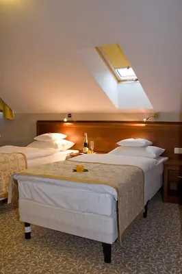 a hotel room with four beds with a skylight at Centuria Hotel & Natural Spa in Ogrodzieniec