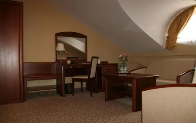 a hotel room with a desk and a mirror at Centuria Hotel & Natural Spa in Ogrodzieniec