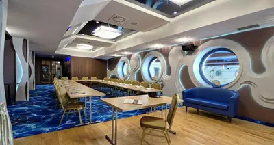 a restaurant with tables and chairs and round windows at Centuria Hotel & Natural Spa in Ogrodzieniec
