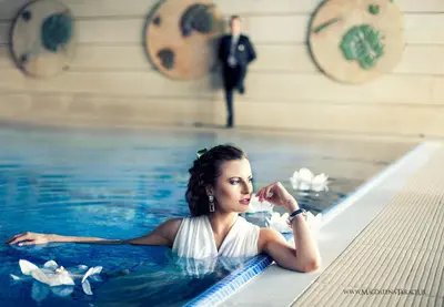 a woman in a swimming pool with a man in the background at Centuria Hotel & Natural Spa in Ogrodzieniec