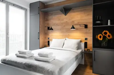 a bedroom with a large bed with towels on it at HOUSEHOST Apartment: Miodowa 42/12a Street in Kraków