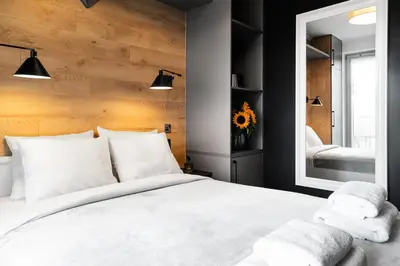 a bedroom with a white bed and a mirror at HOUSEHOST Apartment: Miodowa 42/12a Street in Kraków