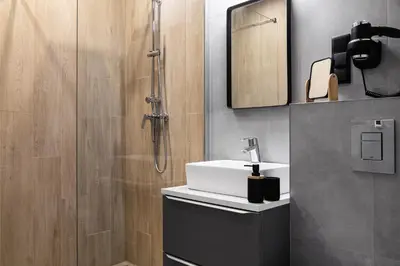 a bathroom with a sink and a shower at HOUSEHOST Apartment: Miodowa 42/12a Street in Kraków