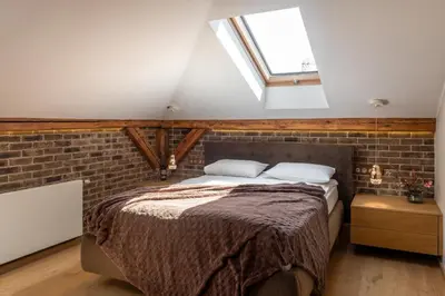 a bedroom with a bed and a brick wall at Skyline by MB Apartments in Kraków