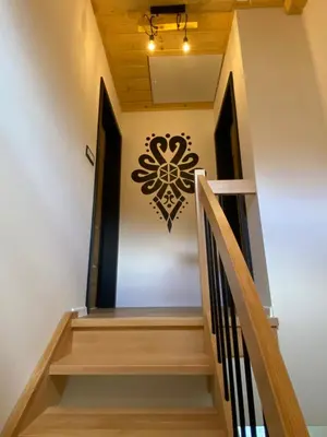 a staircase in a house with a sign on the wall at Zawoja Domki z Jacuzzi in Zawoja