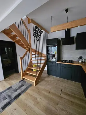 a kitchen with a staircase and a kitchen with a counter at Zawoja Domki z Jacuzzi in Zawoja