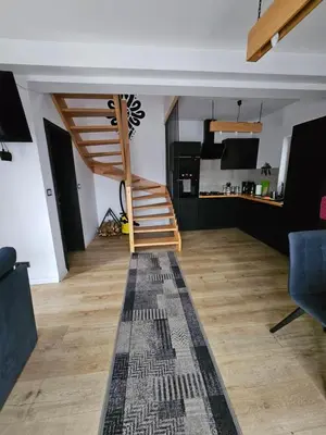 a living room with a staircase and a kitchen at Zawoja Domki z Jacuzzi in Zawoja