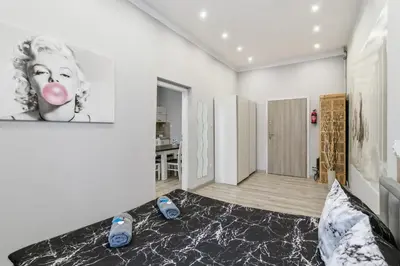 a kitchen with white cabinets and a wooden counter top at Queen Apartments in Kraków